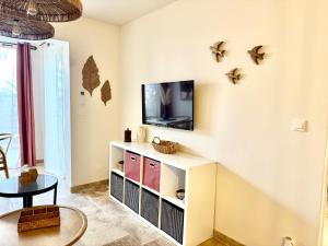 een woonkamer met een tv en een tafel bij LAGON BLEU - Proche Gare Routière - Terrasse & Piscine - 3Km PLAGE - PARKING & WIFI Gratuit - OFFRE SPECIALE in Fréjus