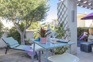 une table bleue et des chaises sur une terrasse en bois avec des arbres dans l'établissement Casa Azul Turquesa, à Lumio
