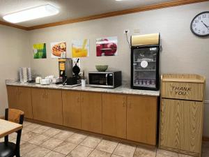 a kitchen with a counter with a microwave and a clock at Quality Inn Arena in Wilkes-Barre