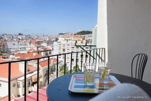 a table with two glasses on top of a balcony at Casa do Beco in Lisbon