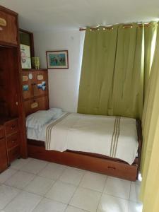 a small bedroom with a bed with green curtains at Apartamento perfecto en Merida Venezuela in Mérida