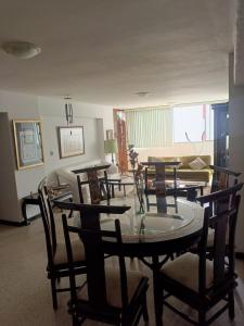 a dining room with a table and chairs and a couch at Apartamento perfecto en Merida Venezuela in Mérida