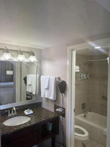 a bathroom with a sink and a toilet and a tub at Best Western InnSuites Phoenix Hotel & Suites in Phoenix
