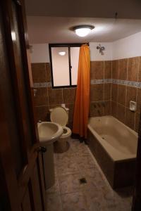 a bathroom with a toilet and a sink and a tub at La Paz Home in La Paz +5 photos