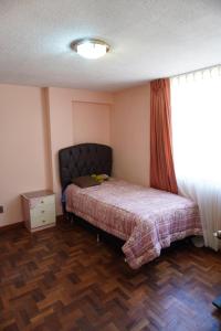 a bedroom with a bed and a window at La Paz Home in La Paz