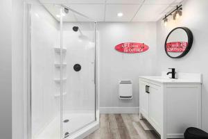 Un baño blanco con ducha y lavabo. en Spacious Oceanview Beach House with hot tub, en Cocagne  41 fotos más