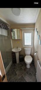 ein Badezimmer mit Toilette und Waschbecken in der Unterkunft Spacious 10 birth Caravan Golden palm resort chapel st leonards Skegness in Chapel Saint Leonards + 17 Fotos