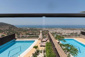 a view of a swimming pool from a building at The Noverian Scenic Crete 5 Star Hilltop Villa Resort & Spa in Malia