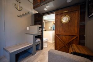 a bathroom with a wooden door and a toilet at Tiny House Pirate Ship - Sleeps 2 near Siesta Key beach in Siesta Key