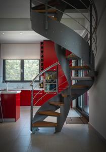 KhortiátisにあるSKYLINE VILLA ESTATE The Luxury Mountain Experienceの赤い壁のキッチンの螺旋階段