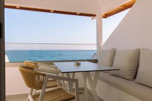 a table and chairs on a balcony with the ocean at Noema in Loutsa
