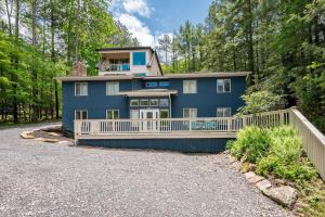 a large blue house with a white fence at Blue Anchor in Swanton