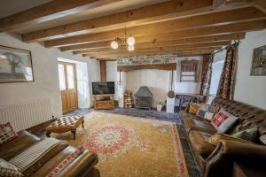 un salon avec un canapé et une cheminée dans l'établissement Cove Cottage, à Llandysul