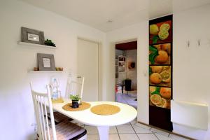 a white table and chairs in a kitchen with a painting on the wall at Haus Sonnenschein in Wiltingen +40 photos