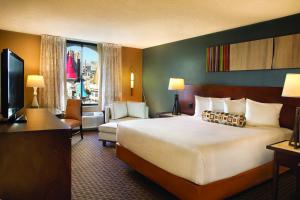 una camera d'albergo con un letto grande e una sedia di Excalibur a Las Vegas Altre 46 foto