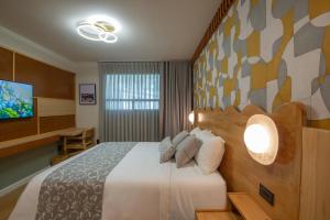 a hotel room with a bed and a flat screen tv at Hotel Boutique Casa Flor de Café in Mexico City