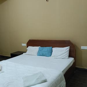 a bedroom with a large bed with white sheets and pillows at One love guest house in Morjim