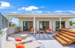 un patio con sedie e tavoli su un edificio di Love Penthouse a Orient Bay