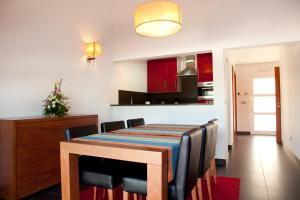 a dining room and kitchen with a table and chairs at Jeiroes Do Mar in Madalena