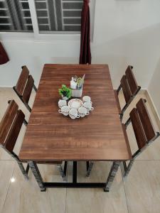 a wooden table with chairs and a tea set on it at Kumbha Nivas in Kumbakonam