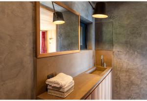 a bathroom with a sink and a mirror and towels at Hourglass Villa's Milos in Psathadika +58 photos