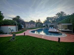 a swimming pool in a yard with a grass field at Hotel Casa da Nora in Leiria