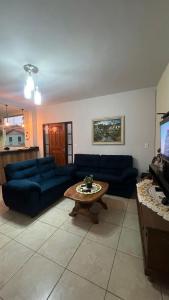 a living room with blue couches and a coffee table at Casa design Piri no centro de Pirenópolis in Pirenópolis