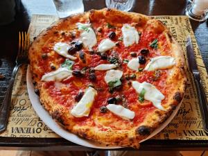 a pizza sitting on a plate on a table at Corte Certosina in Trezzano sul Naviglio
