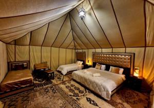 a bedroom with two beds in a tent at Orion Luxury Desert Camp in Merzouga