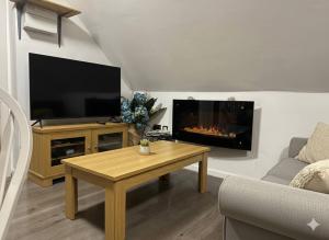 a living room with a tv and a fireplace at Broad Oak Stays 2BR Flat for 6 with Parking in Brede