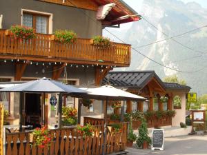 a restaurant with an umbrella in front of a building at La Boule de Neige in Samoëns