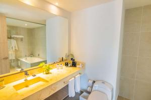 a bathroom with a sink and a toilet and a mirror at Sonesta Hotel Ibagué in Ibagué
