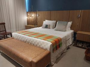 a bedroom with a large bed and a chair at Casa da Orla in Santarém