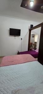 Un dormitorio con una cama y un televisor de pantalla plana. en Departamento Colón a 2 cuadras de la costa, en Mar del Plata