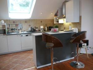 a kitchen with two bar stools at a counter at Holiday Apartment Northern Lights in Oldenburg