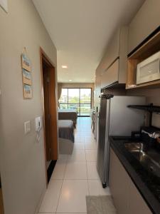 FLAT DE LUXO vista piscinas, Praia de Muro Alto - Malia Beach في إيبوجوكا: مطبخ مع حوض وغرفة مع سرير