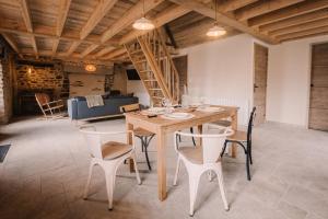 a dining room with a wooden table and chairs at La maison de July in La Roë