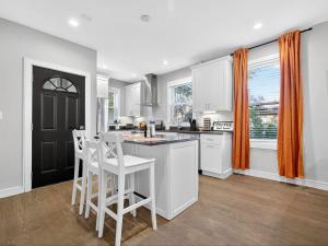 une cuisine avec des placards blancs et deux tabourets blancs dans l'établissement Luxury 3BR apt in Boston that Sleeps 10, à Boston