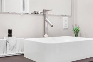 une salle de bains avec un lavabo blanc et un miroir dans l'établissement Luxury 3BR apt in Boston that Sleeps 10, à Boston 34 autres photos