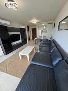 un salon avec un canapé en cuir noir et une table dans l'établissement Premium Apartment in Palm Mar, à Palm-mar