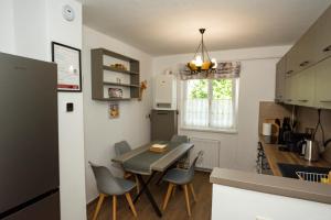 Una cocina y un comedor con mesa y sillas. en Apartment in Odorheiu Secuiesc, en Văleni