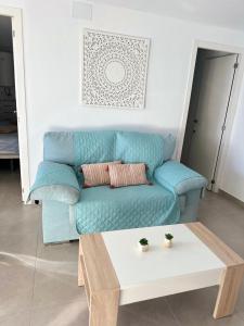 a blue couch in a living room with a coffee table at Delmar Apartment in Alicante
