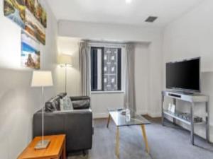Una sala de estar con un sofá y un televisor de pantalla plana. en Superking Bed in Stylish Apartment I Zodiak Stays, en Auckland 8 fotos más