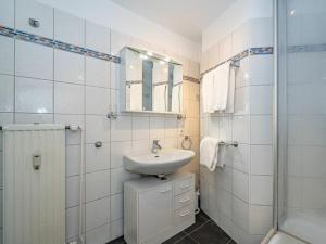 een witte badkamer met een wastafel en een douche bij One-bedroom apartment in Wenningstedt +19 foto's