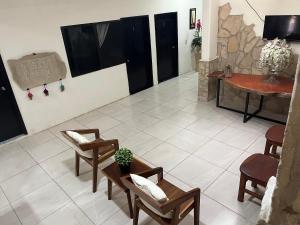 a living room with chairs and a table and a fireplace at Hotel Rio Maya in Palenque