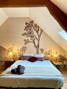 a bedroom with a tree mural on the wall at La maison des Hortillonnages, le calme dans Amiens in Rivery