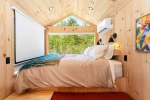 a bedroom with a bed in a room with a window at Aurora Nook-Cabin with Shower & Queen Bed in Sullivan