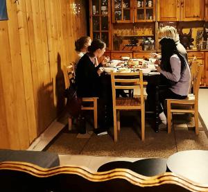 a group of women sitting at a table eating at Elo's Guesthouse in Iprari