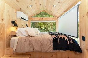 a bedroom in a tiny house with a large window at Vesta Nook With Shower Queen Bed & pullout sofa in Sullivan