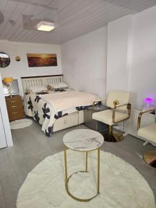 a bedroom with a bed and a table and a chair at Guest house in Le2 in Leicester